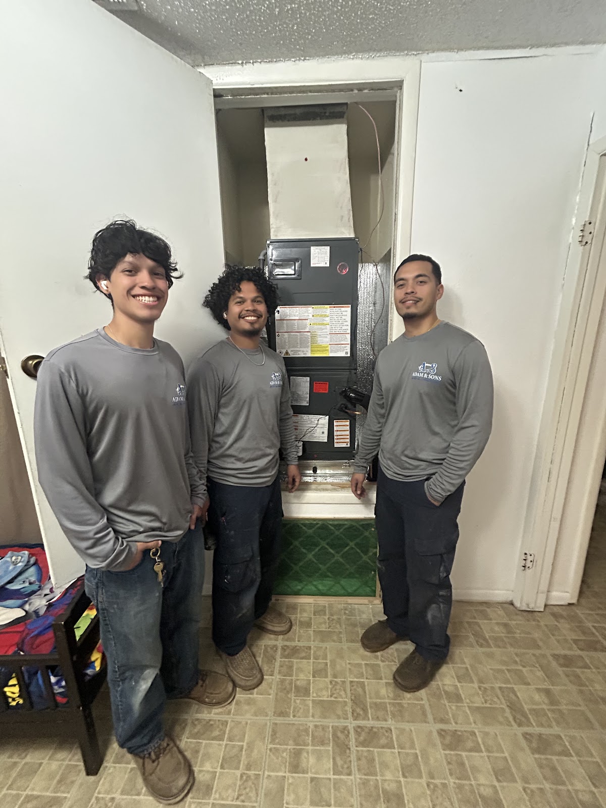 Adam and Sons team in branded uniforms after a completed HVAC install